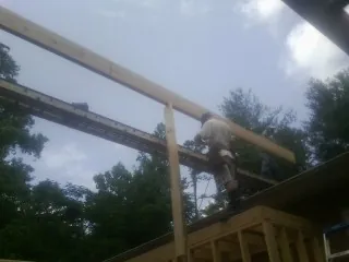 Carpenter setting a ridge beam over a new addition frame — Ice Dam Removal by Roofing Brothers in Carlsbad
