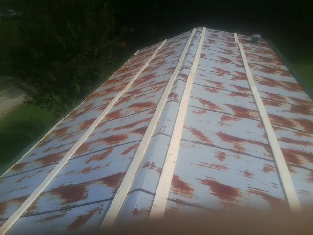 Rusted metal roof panels with new wood purlins before replacement — Storm Damage Roof Repair in Carlsbad by Roofing Brothers